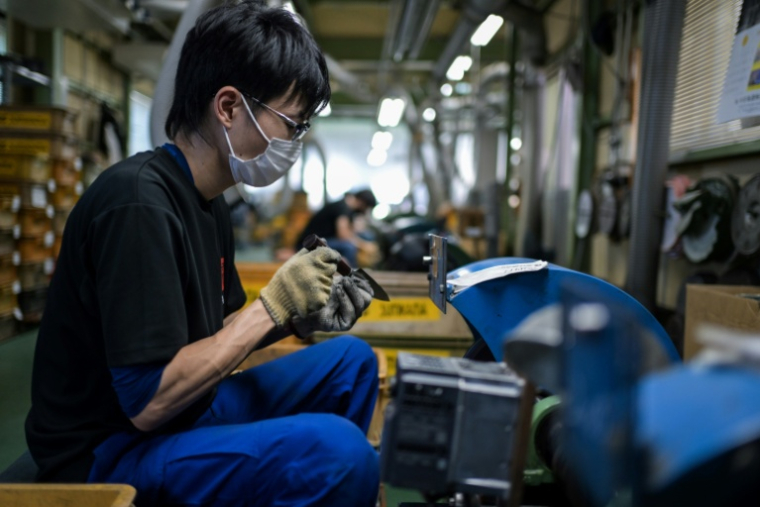 Un employé du fabricant japonais de couteaux Sumikama affûte des lames dans son usine de Seki,au Japon, le 22 juillet 2025 ( AFP / Richard A. Brooks )
