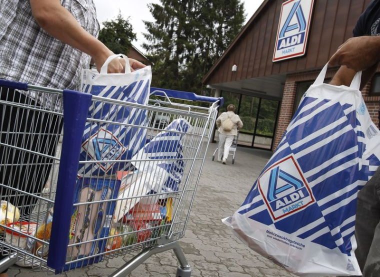 Des clients emballent des marchandises dans des sacs en plastique sur un parking