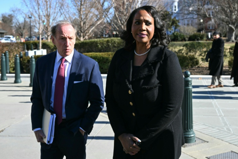 La gouverneure de la Fed Lisa Cook (d), accompagnée d'un avocat, fait une déclaration à la presse devant la Cour suprême américaine, le 21 janvier 2026 à Washington ( AFP / Brendan SMIALOWSKI )