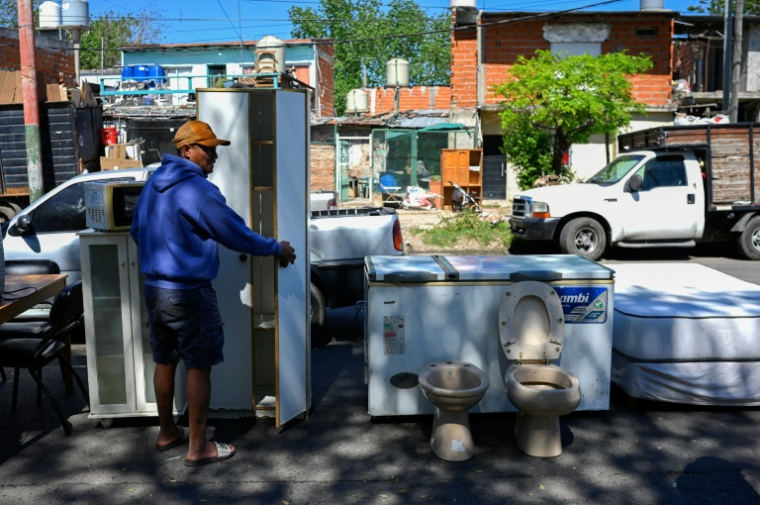 Des meubles, de l'électro-ménager et des objets sanitaires d'occasion vendus surmarché de rue à Villa Fiorito, dans la banlieue de Buenos Aires, le 19 octobre 2025 en Argentine ( AFP / Luis ROBAYO )