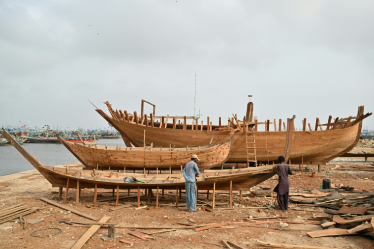 Des artisans construisent des bateaux traditionnels en bois dans le quartier Ibrahim Hyderi à Karachi, Pakistan, le 8 juillet 2026  ( AFP / Asif HASSAN )