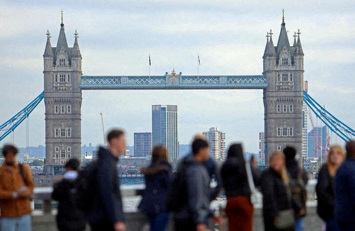 Des personnes marchent sur le London Bridge avec une vue du Tower Bridge à Londres