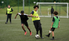 Fabian Myers (c) et Kaziah Cameron (2e g), élèves du collège-lycée publicOur Lady and St Chad Catholic Academy et participants du programme "Football Beyond Borders" (FBB), disputent un match de foot avec d'autres élèves du programme à Wolverhampton, le 12 juin 2026 au Royaume-Uni ( AFP / Oli SCARFF )