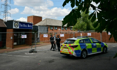 Des policiers entrent par une clôture à l'hôtel Bell, censé héberger des demandeurs d'asile, à Epping, au nord-est de Londres, le 18 juillet 2025, après des manifestations anti-immigration ( AFP / Ben STANSALL )
