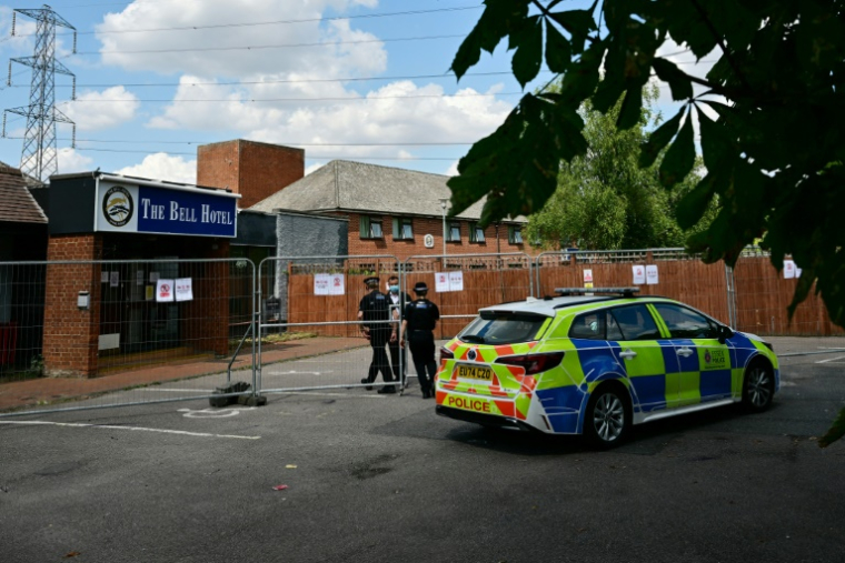 Des policiers entrent par une clôture à l'hôtel Bell, censé héberger des demandeurs d'asile, à Epping, au nord-est de Londres, le 18 juillet 2025, après des manifestations anti-immigration ( AFP / Ben STANSALL )