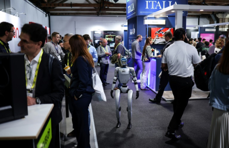 Un robot parmi des visiteurs au salon de l'IA à Londres, le 11 juin 2025  ( AFP / HENRY NICHOLLS )