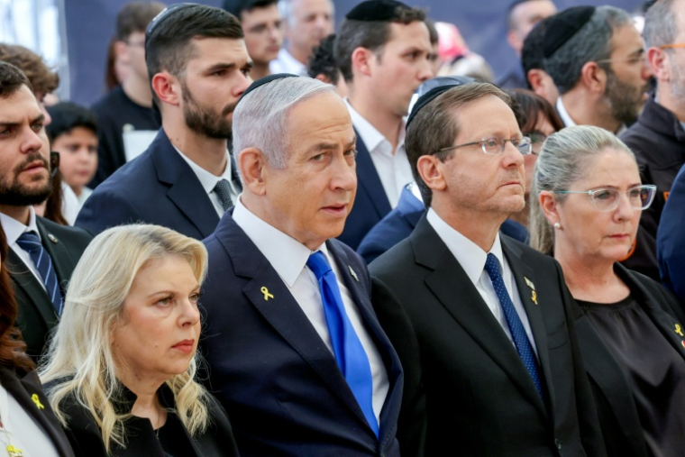 (g-d) Sara Netanyahu, l'épouse du Premier ministre israélien, Benjamin Netanyahu, le président Isaac Herzog et la Première dame Michal Herzog assistent à une cérémonie commémorative en hommage aux Israéliens tués, le 27 octobre 2024, au cimetière militaire du Mont Herzl à Jérusalem ( POOL / GIL COHEN-MAGEN )