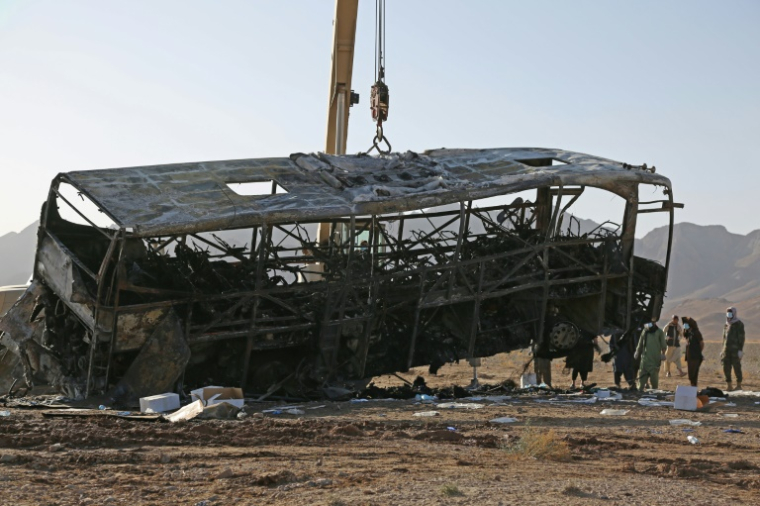 Une grue soulève l'épave d'un bus après un accident meurtrier dans le district de Guzara, dans la province d'Hérat, le 20 août 2025 en Afghanistan ( AFP / Mohsen KARIMI )