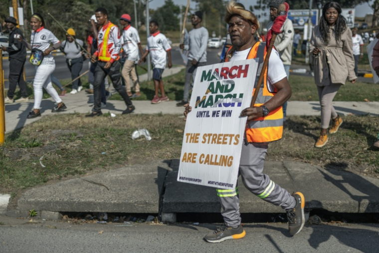 Un manifestant du mouvement March and March brandit une banderole lors d’une manifestation à Pinetown, au sud de Durban, le 16 juillet 2026 ( AFP / RAJESH JANTILAL )