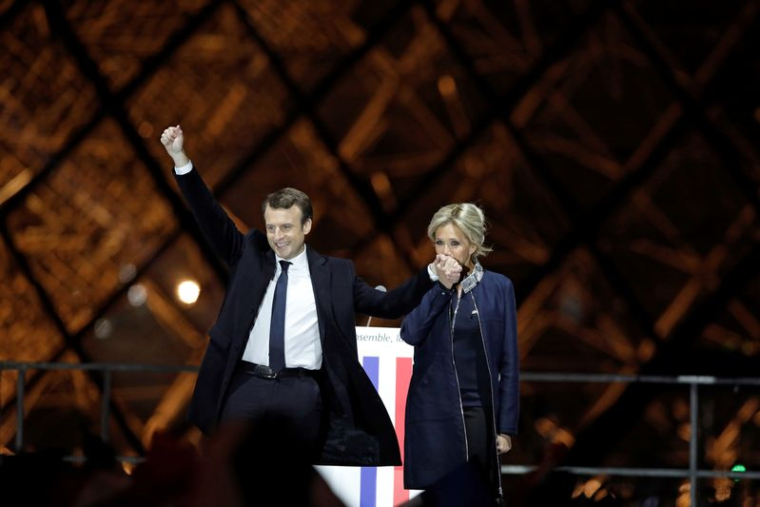 Le président français élu Emmanuel Macron et son épouse Brigitte Trogneux célèbrent sur la scène lors de son rassemblement de victoire près du Louvre à Paris, en France, le 7 mai 2017.