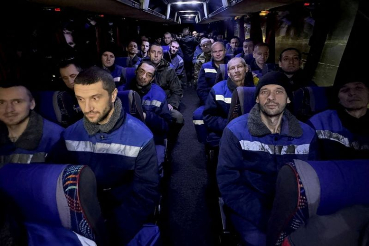 Des prisonniers de guerre ukrainiens assis dans un bus après un échange