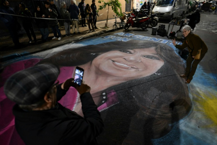 Des partisans de l'ex-présidente argentine Cristina Kirchner prennent une photo d'une fresque au sol représentant celle-ci, le 17 juin 2025 à Buenos Aires ( AFP / Luis ROBAYO )