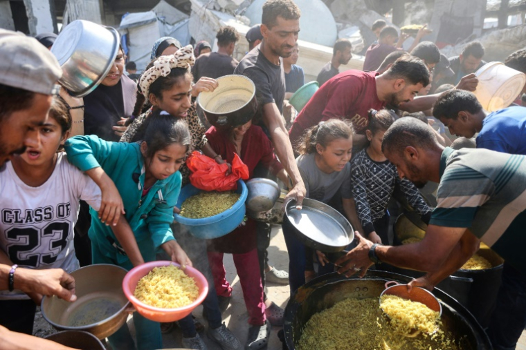 Des déplacés palestiniens dont ds enfants se rassemblent pour recevoir des rations alimentaires dans le quartier de Zeitoun à Gaza-ville, le 23 octobre 2025 ( AFP / Omar AL-QATTAA )