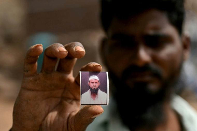 Cheikh Imran montre une photo de son frère Cheikh Latif Sheru, un agriculteur qui s'est suicidé en raison de l'accumulation de prêts financiers, sur leurs terres agricoles dans le village de Mochi Pimpalgaon, dans l'Etat du Maharashtra, le 3 mai 2025 en Inde ( AFP / Indranil MUKHERJEE )