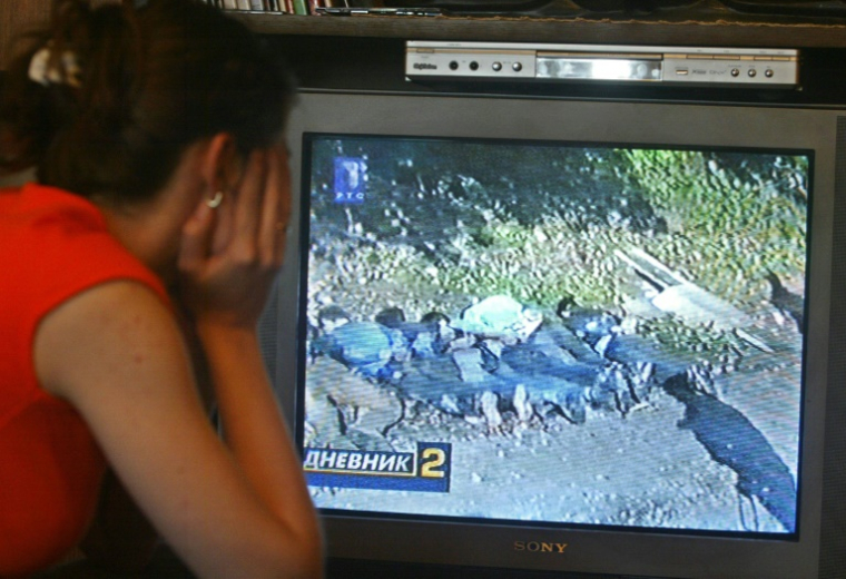 Une femme regarde un reportage à la télévision, le 2 juillet 2005 à Belgrade, qui montrerait des paramilitaire serbes exécutant six Bosniaques musulmans de Srebrenica ( AFP / KOCA SULEJMANOVIC )