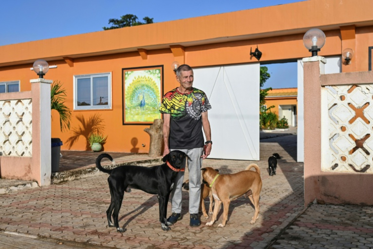 Raynald Gilon, ancien parachutiste belge, garde forestier et aujourd'hui directeur d'hôtel, devant le Safari Lodge avec ses chiens, le 10 octobre 2025 à Kafolo, en Côte de d'Ivoire ( AFP / Issouf SANOGO )