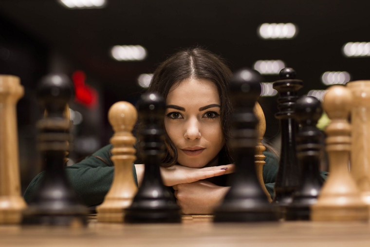 Femme jouant aux échecs (Crédits: Adobe Stock)