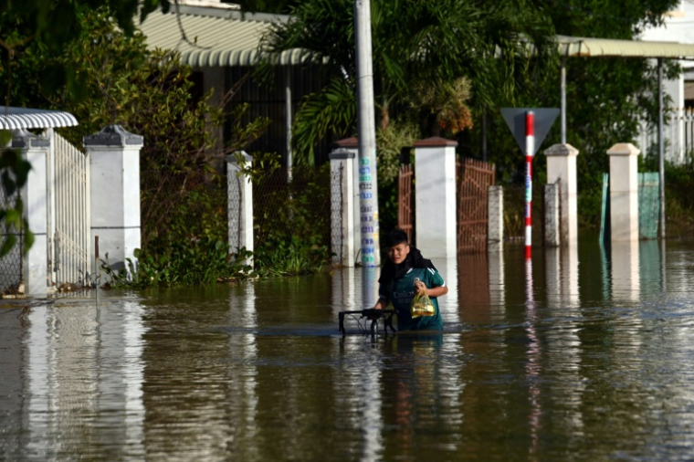 Un homme avance avec son vélo dans une rue inondée de Lam Dong, au Vietnam, le 5 décembre 2025 ( AFP / Quoc Nguyen )