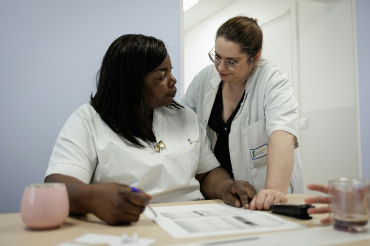 Barkissa Bance (G), responsable de l'unité d'accueil pour enfants en danger (Uaped), s'entretient avec l'infirmière Céline Cazaux (D), au centre hospitalier sud francilien de Corbeil-Essonnes, le 30 juin 2026 ( AFP / Simon WOHLFAHRT )