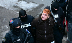 Mohamed Amra escorté par des policiers, le lendemain de son arrestation à Bucarest le 23 février 2025 ( AFP / Daniel MIHAILESCU )