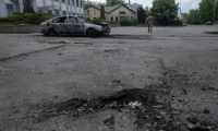 Photo prise le 16 mai 2025 et publiée le 17 mai 2025 par le service de presse de la 93e brigade mécanisée séparée de Kholodnyi Yar des forces terrestres ukrainiennes montrant un cratère à côté d'une voiture calcinée et le corps d'une victime à l'intérieur après une attaque de drone à Kostyantynivka, dans la région de Donetsk ( service de presse de la 93e brigade mécanisée séparée de Kholodnyi Yar / Iryna Rybakova )