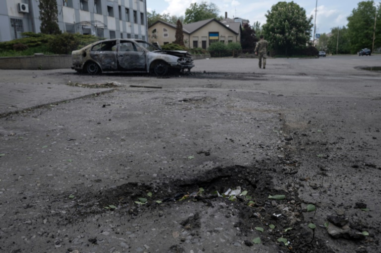 Photo prise le 16 mai 2025 et publiée le 17 mai 2025 par le service de presse de la 93e brigade mécanisée séparée de Kholodnyi Yar des forces terrestres ukrainiennes montrant un cratère à côté d'une voiture calcinée et le corps d'une victime à l'intérieur après une attaque de drone à Kostyantynivka, dans la région de Donetsk ( service de presse de la 93e brigade mécanisée séparée de Kholodnyi Yar / Iryna Rybakova )