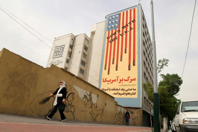 Une fresque murale avec le slogan "A bas les Etats-Unis" et des têtes de mort remplaçant les étoiles du drapeau américain, à Téhéran, le 26 avril 2025 ( AFP / ATTA KENARE )