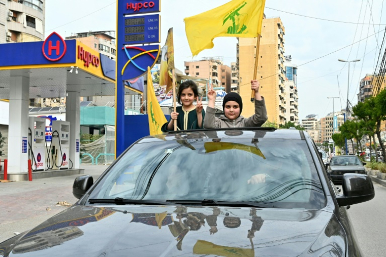 Des fillettes agitent des drapeaux du Hezbollah tandis que des déplacés rentrent dans un quartier de la banlieue sud de Beyrouth après l’entrée en vigueur d’un cessez-le-feu avec Israël, le 17 avril 2026 ( AFP / FADEL itani )