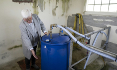 Annick Dufils, maire de Malandry (Ardennes), devant une installation expérimentale destinée à filtrer de l'eau polluée aux PFAS, le 30 septembre 2025 ( AFP / Jean-Christophe VERHAEGEN )
