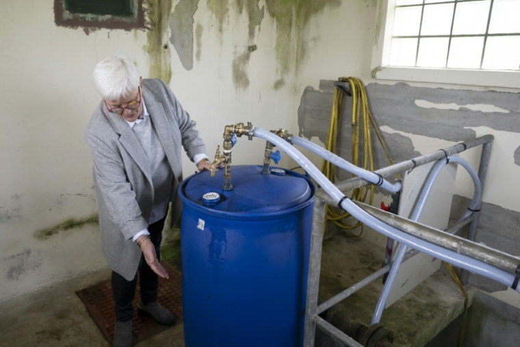 Annick Dufils, maire de Malandry (Ardennes), devant une installation expérimentale destinée à filtrer de l'eau polluée aux PFAS, le 30 septembre 2025 ( AFP / Jean-Christophe VERHAEGEN )