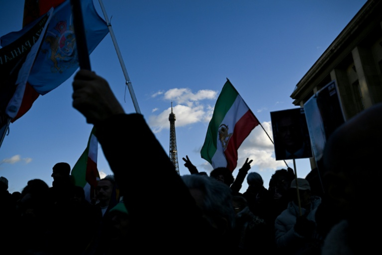Des manifestants brandissent des drapeaux iraniens d'avant la révolution islamique de 1979 durant un rassemblement à Paris en soutien aux manifestants iraniens, le 4 janvier 2026 ( AFP / Blanca CRUZ )