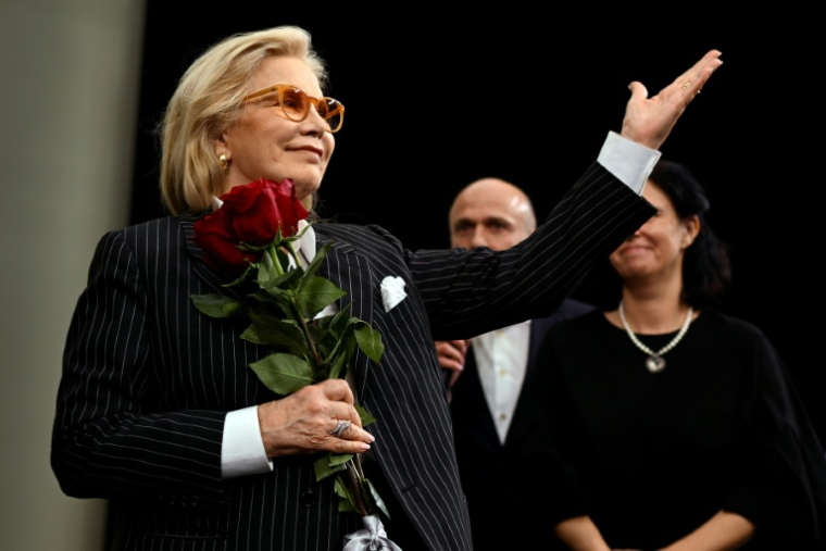 Sylvie Vartan fait un signe au public venu assister à la première d'un documentaire lui étant consacré, le 25 octobre 2025 à Sofia  ( AFP / Nikolay DOYCHINOV )