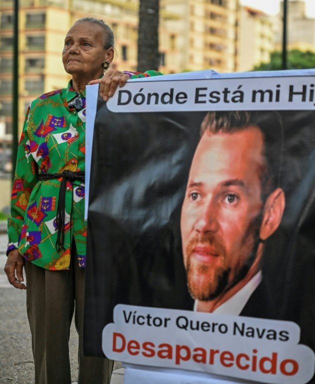 Carmen Nava pose à côté d'une photo de son fils, le prisonnier politique Victor Quero Navas, à Caracas, le 30 avril 2026 ( AFP / Maryorin Mendez )
