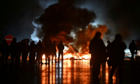 Des manifestants du mouvement "Bloquons tout" près d'objets en feu sur le viaduc de Calix, le 10 septembre 2025 ( AFP / Lou BENOIST )
