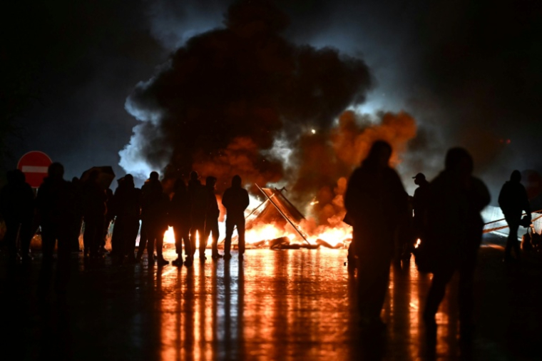 Des manifestants du mouvement "Bloquons tout" près d'objets en feu sur le viaduc de Calix, le 10 septembre 2025 ( AFP / Lou BENOIST )