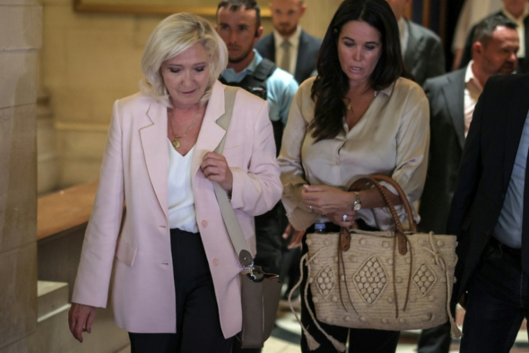 Marine Le Pen, présidente du groupe parlementaire du Rassemblement national (g), accompagnée de la députée européenne Catherine Griset (d), quitte la cour d'appel de Paris le 7 juillet 2026, après le prononcé de l'arrêt en appel pour détournement de fonds publics européens dans l'affaire des emplois présumés fictifs au Parlement européen ( AFP / Kenzo TRIBOUILLARD )