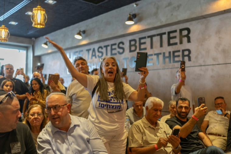 Des partisans du Premier ministre israélien Benjamin Netanyahu, attendent son arivée dans un café à Dimona, le 21 octobre 2026 en Israël ( AFP / Ilia YEFIMOVICH )