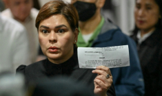 La vice-présidente philippine Sara Duterte brandit le reçu de versement de sa caution, au tribunal en banlieue de Manille, le 5 septembre 2026 ( AFP / Ted ALJIBE )