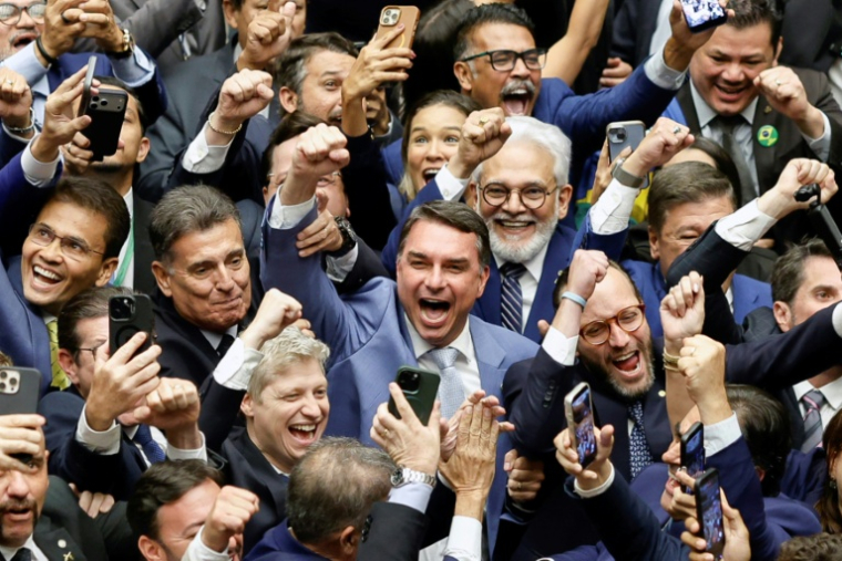 Le sénateur Flavio Bolsonaro (c) célèbre, la levée du veto du président Lula sur un projet de loi réduisant les peines des personnes condamnées pour la tentative de coup d'Étatdu 8 janvier 2023, à l'issue d'une session du Congrès national, le 30 avril 2026 à Brasilia, au Brésil ( AFP / Sergio Lima )