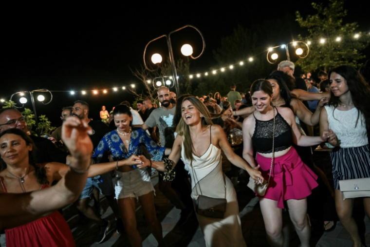 Locaux et vacanciers dansent un "panigiri", une tradition en Grèce, au village du Prophète Elie, sur l'île d'Ikaria, le 20 juillet 2025 ( AFP / Aris MESSINIS )