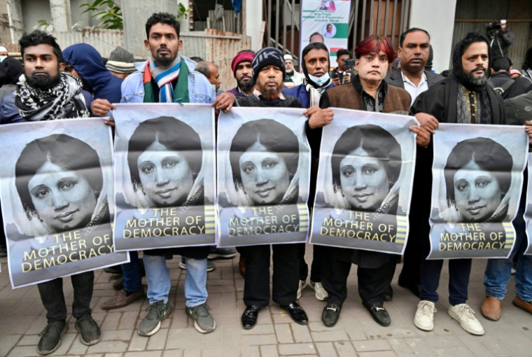 Des partisans de l'ancienne Première ministre du Bangladesh Khaleda Zia brandissent des portraits de la dirigeante décédée, le 30 décembre 2025 à Dacca ( AFP / Munir UZ ZAMAN )