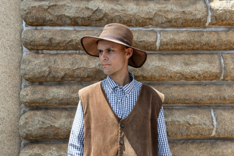 Un participant en habits de Voortrekker regarde des Afrikaners se rassembler pour célébrer le Jour du serment, au monument des Voortrekkers à Pretoria (Afrique du Sud), le 16 décembre 2025 ( AFP / Wikus de Wet )