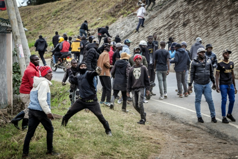 Des hommes lancent des pierres lors d'affrontements à Nairobi, le 21 août 2025 au Kenya ( AFP / Luis TATO )