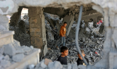 Des garçons marchent parmi les décombres d’un bâtiment endommagé, qui abritait des personnes déplacées dans le quartier de Zeitoun, à Gaza-Ville, le 20 novembre 2025, au lendemain d'une frappe israélienne ( AFP / Omar AL-QATTAA )