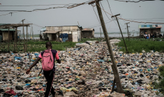 Un homme marche sur des déchets plastiques, dans la région de Mosafejo à Lagos (Nigeria) le 12 février 2019. Photo d'illustration.  ( AFP / YASUYOSHI CHIBA )