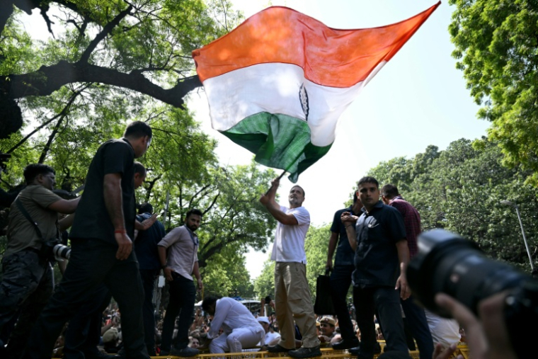 Le chef de l’opposition indienne Rahul Gandhi (c) brandit le drapeau national au cours d'une marche de protestation contre la Commission électorale, accusée d'avoir radié à tort des millions d'électeurs, à New Delhi le 6 octobre 2026 ( AFP / Arun SANKAR )