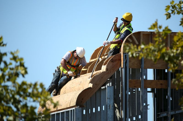 Des démolisseurs démontent l'enseigne et la façade d'un restaurant à Rockville, dans le Maryland