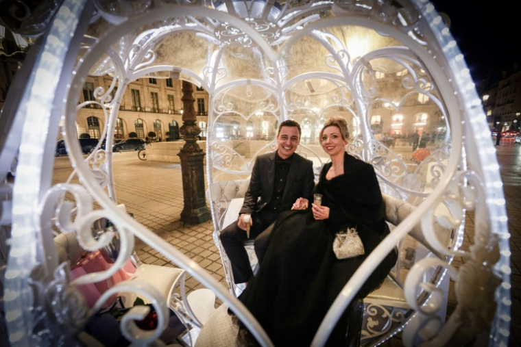 Le couple néerlandais Shirley Wijgaarts et Sander Castel (g) assis dans un carrosse digne d'un conte de fées, lors de leur demande en mariage, place Vendôme à Paris, le 7 février 2026 ( AFP / STEPHANE DE SAKUTIN )