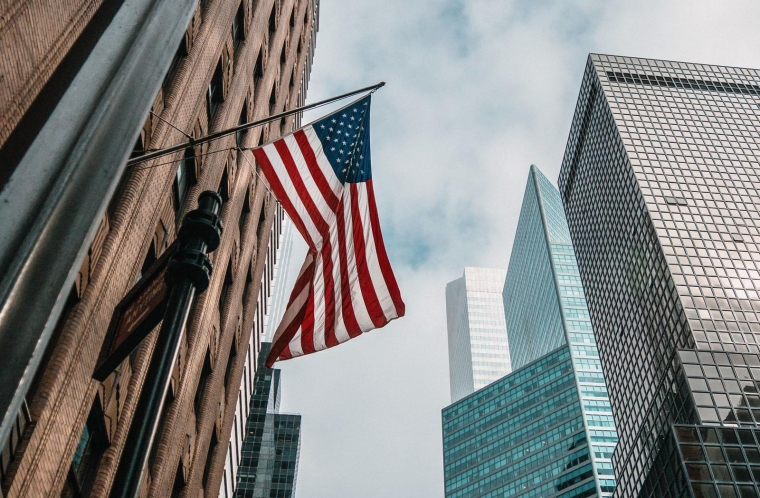 drapeau américain et building (Crédits: Unsplash - Nik Shuliahin)