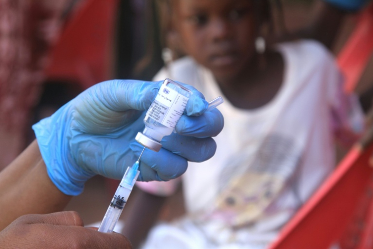 Un enfant soudanais observe la préparation d'un vaccin lors d'une campagne de vaccination contre la diphtérie dans un camp de déplacés dans la ville d'Al-Dabbah, dans le nord du Soudan, le 22 novembre 2025 ( AFP / Ebrahim Hamid )